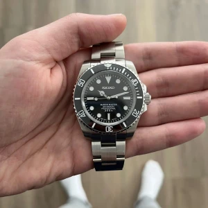 Seiko mod - Säljer en svart Seiko klocka (mod)  med en snygg silverfärgad länkarmband. Klockan har en schysst urtavla med datumvisning och är vattentät upp till 300. Följ för mer feta saker!🍾🥂🍾