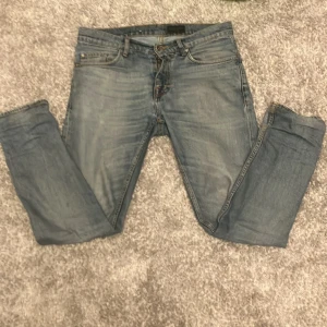 Blå jeans från Tiger of Sweden - Snygga blå jeans från Tiger of Sweden i modellen Pistolero. De har en klassisk femficksdesign och en bekväm passform. Perfekta för en stilren look.