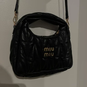 Svart väska med guld detaljer - Super snygg väska i gott skick men på sista bilden ser man att guldet släppt lite på bokstäverna men det ser man verkligen inte om man inte kollar jätte nära.