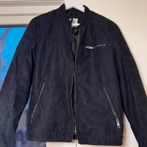 Svart jacka från Jack & Jones - Snygg svart jacka från Jack & Jones med dragkedja och flera fickor. Perfekt för en stilren look. Jackan har långa ärmar och en modern design.