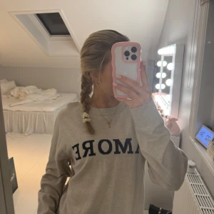 Beige tröja med text - Säljer en beige tröja med svart text på framsidan. Tröjan har långa ärmar och en avslappnad passform. Perfekt för en casual look.