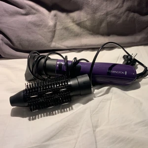 Lila varmluftsborste från Remington - Säljer en lila hårtork från Remington. Den har en rund borste med svarta borst och ett ”vanligt” munstycke som torkar håret, samt en sladd för enkel användning. Kontrollerna med värme alt kyla är lättåtkomliga på handtaget. Hör av dig vid frågor💕