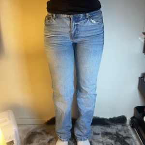 Blå jeans - Snygga blå jeans med låg midja och klassisk femficksdesign. De har en straight passform som ger en tidlös look. Perfekta för en avslappnad stil.
