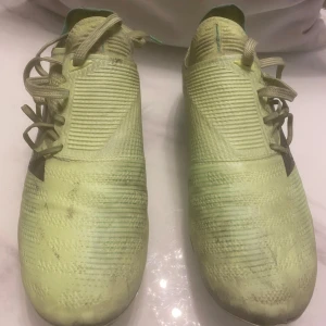 Gröna fotbollsskor från New Balance - Säljer ett par gröna fotbollsskor vid namn ”New Balance Furon V7 PRO” vilket är New Balances topp model när det gäller fotbollsskor. Furon används av fotbollsstjärnan Bukayo Saka och med en strump känsla runt foten och med en fantastisk känsla med bollen så blir det mål varje match. Skorna har använts i två veckor men säljs nu då de ej används längre. Skorna har tappat färg på sulan men har inga defekter och funkar fantastisk bra utan några problem. Priset kan även diskuteras. 