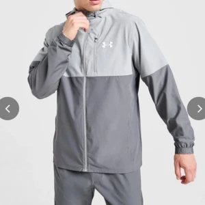  Under Armour vindjacka  - Säljer en stilren grå vindjacka från Under Armour. Jackan är oanvänd och kommer även med prislapp. Dm för bilder 