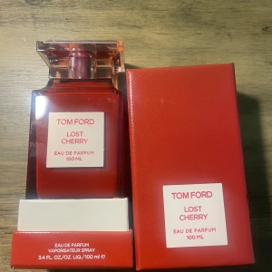 Tom Ford Lost Cherry Eau de Parfum 100 ml - Tom Ford Lost Cherry Eau de Parfum i en lyxig röd kartong med vit etikett. Flaskan rymmer 100 ml och doften är känd för sina söta och fruktiga körsbärstoner. Förpackningen är elegant och exklusiv, perfekt för dig som gillar unika och djärva parfymer. Parfymen är fortfarande inplastad alltså att DEN ÄR HELT FULL! och inte har använts. nypris: 3000-5000