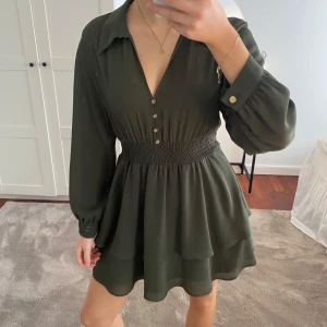 Mörkgrön volangklänning - Så fin grön klänning med guldknappar som jag köpte på Zara för 2 år sedan. Väldigt fint skick, nästintill som ny, luftig och flowig. Den har en tunn och mjuk underkjol så den är inte genomskinlig! Storlek Xs men passar S bra också. Har flera klänningar liknande denna så därför säljer jag tyvärr denna skönheten 💚Pris kan diskuteras men klicka gärna köp nu!