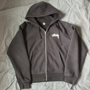 Stussy Zip Hoodie - Köpte denna under Stussys Höst 2022 drop i affären dom har i London. Storlek XL men passar L med. Tvärbra material och bra skick. Tveka inte o fråga om ni har några mer frågor. Pris är diskuterbart :)