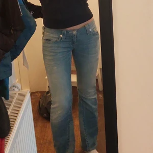True Religion Jeans  - Säljer dessa sjukt snygga lågmidjade bootcut jeans från True Religion i storlek 27, de var skinny från början men har sytt ut till bootcut, de är i superbra skick. Midjemått tvärs över: 39cm Innerbensläng: 80cm Skriv om fler frågor, priset kan diskuteras