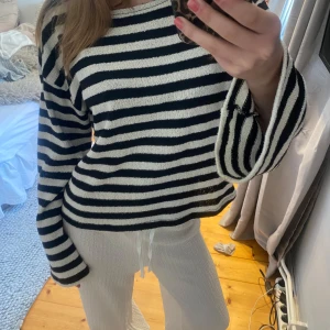 Svartvit randig stickad tröja - Säljer en svartvit randig stickad tröja med långa ärmar och rund halsringning. Denna tröjan är endast använd få tal gånger.