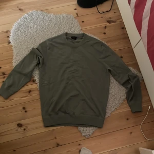 Olivgrön stickad tröja från Massimo Dutti - Säljer en stilren olivgrön stickad tröja från Massimo Dutti. Tröjan har två stycken fläckar av svart på ställen där de inte syns så värst mycket. Därför är priset lite lägre! Säljer tröjan då den inte används längre. 