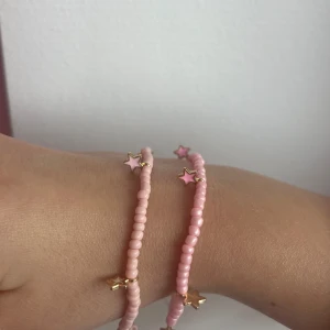 2 pack rosa armband med rosa stjärnor  - Säljer dessa två armband med rosa stjärnor för 25kr. :) fås i presentpåse 💗