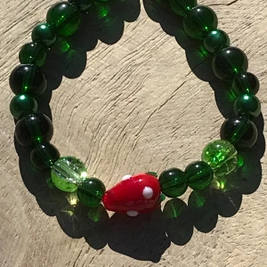 Armband  - Vackert armband i mörkgröna glaspärlor och en jordgubba 🍓🍃