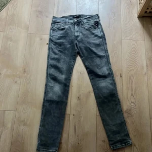 Grå slim jeans - Säljer ett par grå slim fit jeans med klassisk femficksdesign och dragkedja. Jeansen har en något tvättad look och raka ben. Perfekta till vardags för en stilren outfit.