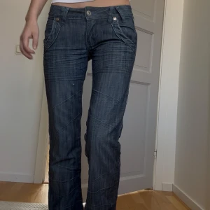 Mörkblå lågmidjade jeans - Säljer ett par mörkblå jeansbyxor med låg midja och raka ben. Kommer aldrig till användning längre så säljer. De har ett litet hål på höger ben men det tänker man inte på och går lätt att fixa❣️