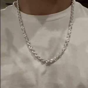 925 äkta silver kedja  - Säljer ett snyggt halsband i silverfärg med tvinnad kedja. Perfekt accessoar för att lyfta din stil. Passar både till vardags och när du vill sticka ut lite extra. Kedjan har en robust och glansig finish.