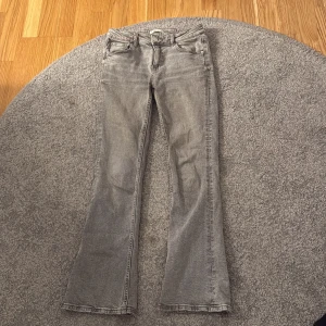 Grå bootcut jeans från Gina Tricot - Säljer ett par grå jeans från Gina Tricot i storlek 152. Byxorna har klassisk femficksdesign, normal passform upptill och bootcut-ben. Perfekta för dig som gillar en tidlös look med lite utsvängda ben.