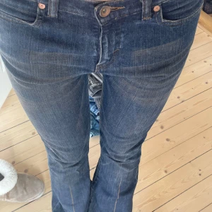 Mörkblå lågmidjade jeans  - Så snygga jeans i mörkblå färg! Har bruna detaljer på. Färgen syns bäst på första bilden🥰långa ben!