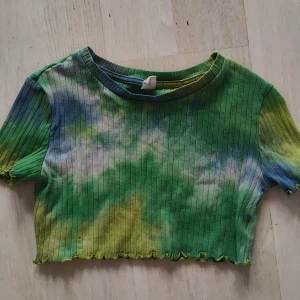 Färgglad ribbad topp  - Säljer en cool ribbad topp från Shein i gröna, blå och gula nyanser med ett tie-dye mönster. Toppen är croppad och har korta ärmar, perfekt för en färgglad stil.