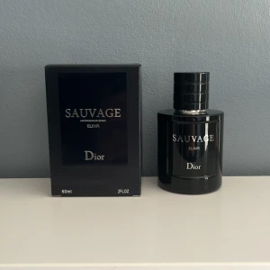 Sauvage Elixir från Dior - Säljer en elegant och intensiv parfym, Sauvage Elixir från Dior. Flaskan är mörk och stilren med en kapacitet på 60 ml. Perfekt för den som söker en kraftfull och sofistikerad doft.