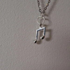 Halsband med silvernot - Snyggt halsband med en hängande silvernot som berlock. Perfekt för musikälskaren! Kedjan är tunn och elegant, vilket gör det lätt att bära till olika tillfällen.