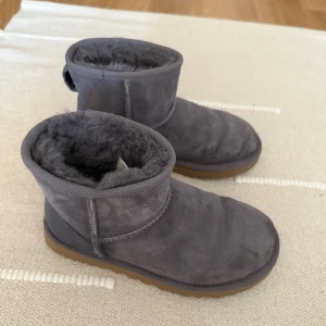 Grå UGGs - Grå/lila aktiga UGGs, knappt använda då de var lite små. De har några små vattenfläckar på sig. Nypris ca 2 000 kr