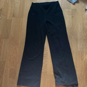 Svarta kostymbyxor från Gina Tricot - Snygga svarta kostymbyxor från Gina Tricot i storlek S. Byxorna har en hög midja och en rak passform som ger en stilren look. Perfekta för en chic och elegant stil. Innebenslängden är 74cm. Midjemått 34 cm.