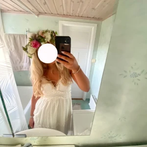 Vit klänning från Vero Moda  - Vit klänning med prickigt mönster och volangdetaljer. Klänningen har en v-ringad design och är ärmlös. Perfekt till studenten eller midsommar! 💕 Bra skick! Storlek S! Tredje bilden är lånad.