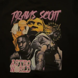Svart hoodie från Iconic Family Member - Säljer en svart hoodie från Iconic Family Member med en cool Travis Scott Astroworld-design på framsidan. Den är i storlek XL och har en klassisk huva med dragsko. Perfekt för dig som gillar streetwear och vill ha något unikt i garderoben. Helt DeadStock. Passar L och mer baggy för M. Använts 1 gång.