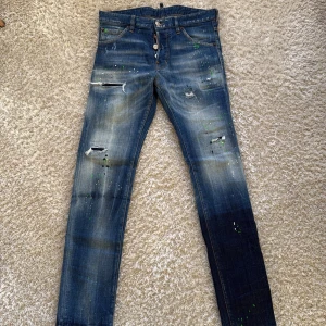 DSQUARED2 nya!  - Snygga blå DSQUARED2  jeans med coola slitningar och gröna färgstänk. Storlek 46 passform slim 