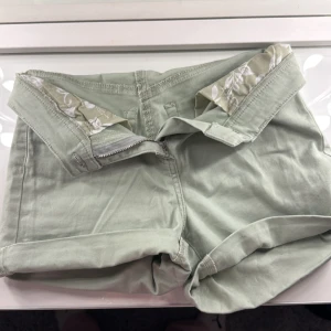 Gröna shorts - Snygga ljusgröna shorts med uppvikta ben och två bakfickor. Perfekta för en avslappnad stil. De har en dragkedja framtill och ett mönstrat innerfoder som ger en extra touch. Aldrig använda💘