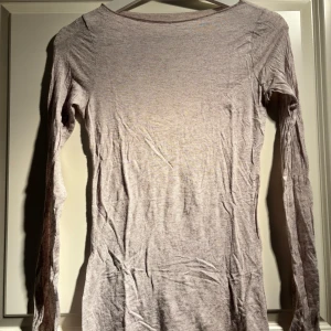 Beige långärmad tröja från Intimissimi - Säljer en ultralätt beige långärmad tröja från Intimissimi, tillverkad med kashmir för extra mjukhet. Perfekt för lager-på-lager under kyliga dagar. Tröjan har en enkel och stilren design.