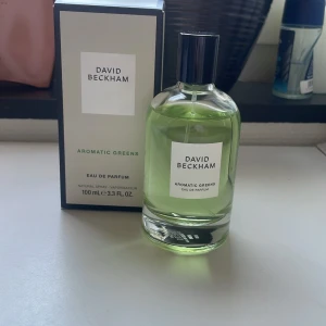 David Beckham Aromatic Greens edp 100ml - Säljer en flaska Aromatic Greens Eau de Parfum från David Beckham. Parfymen kommer i en elegant, genomskinlig flaska med grön vätska och svart kork. Förpackningen är stilren med vita och gröna detaljer. En fräsch, grön och aromatik parfym, funkar bäst för våren och sommaren. 95ml kvar!