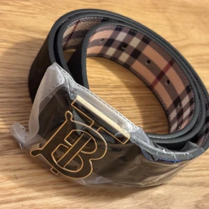 Burbery bälte  - Svart med guld loga storlek 115cm