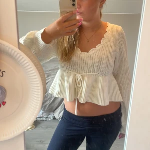 Vit kofta med snöre och volang - Supersöt vit kofta från Shein med volangkant,  och knyt i midjan. Tröjan har långärmade ärmar, scallop-detaljer vid halsringningen och är croppad. Perfekt för lager-på-lager och ger en romantisk vibe.