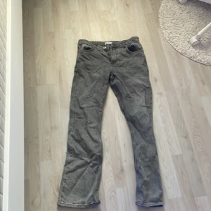 Grå bootcut jeans från Gina Tricot - Snygga grå jeans från Gina Tricot, modell Perfect Jeans. De har klassisk femficksdesign, raka ben med lätt bootcut och normal passform. Jeansen är i ett mjukt bomullsmaterial med lite stretch för extra komfort. Perfekta till sneakers eller boots.
