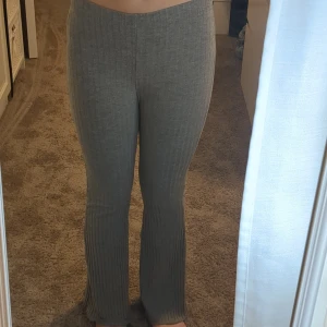 Grå ribbade byxor från Shein - Grå ribbade byxor från Shein med utsvängda ben och hög midja. Byxorna är stretchiga och har en mjuk känsla. Passar dig som gillar bekväma och snygga plagg med lite extra stil.💞