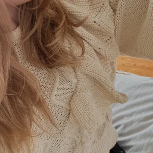 Beige stickad tröja - Superfin beige stickad tröja från Only med snyggt kabelstickat mönster och volangdetaljer på axlarna. Tröjan har rund halsringning och långa ärmar med ribbade muddar. Jätte snygg till ett par jeans💕