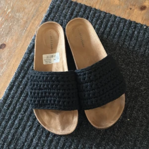 Svarta sandaler från Attitude, stl 38 - Snygga sandaler från Attitude i storlek 38. Ovandelen är svart och grovt virkad, vilket ger en cool och trendig look. Perfekta för varma dagar när du vill vara både bekväm och stilren. De är helt nya bara använda en gång💕