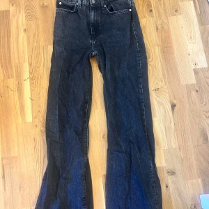 Svarta wide jeans från 157, stl S - Säljer ett par svarta jeans från 157 i storlek S. Jeansen har en rak och lite vidare passform med klassiska fem fickor och bälteshällor. Materialet är kraftigt denim och färgen är mörkt svart med lite tvättad look. Perfekta till sneakers eller boots.