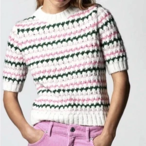Randig stickad tröja från Zara - Superfin stickad tröja från Zara med korta ärmar och randigt mönster i vitt, rosa och grönt. Tröjan har ribbade muddar. Perfekt för dig som gillar färg och retrovibbar!
