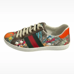 Gucci sneakers med Disney-tryck - Säljer min kompis unika Gucci sneakers med färgglatt Disney-tryck, featuring Kalle Anka och knattarna. Skorna har klassiska gröna och röda ränder på sidan, orange detalj på hälen och snörning framtill. 