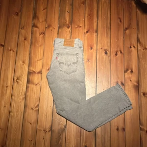Levi's 511 ljusgrå jeans W31 L32 - Snygga ljusgrå Levi's 511 jeans med klassisk femficksdesign och raka ben. Jeansen har en slim passform och är tillverkade i mjukt bomullsmaterial. Perfekta för dig som gillar en clean och stilren look. Ikonisk läderpatch bak i midjan och röd Levi's-tagg på bakfickan. Kom gärna med frågor och pruta för en snabb affär 