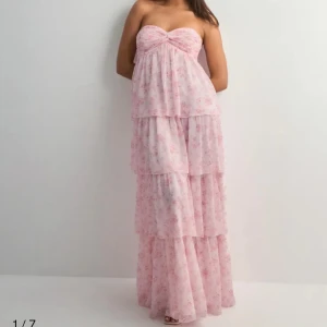 Ljusrosa blommig maxiklänning med volanger - Säljer min superfina och oanvända klänning från Nelly då den är lite för lång på mig! Lapparna sitter kvar🫶🏻