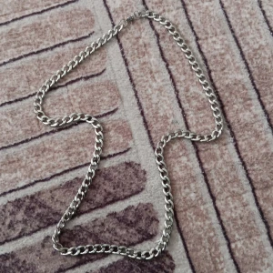 Kedjehalsband i silverfärg - Stilrent halsband med breda, platta länkar i silverfärg. Kedjan har en klassisk design som passar perfekt till streetwear eller för att ge outfiten lite extra edge. Länkarna är blanka och ger ett snyggt intryck. Perfekt accessoar för dig som gillar minimalistisk stil.