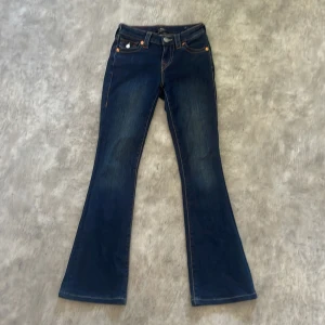 True Religion Becca Bootcut Jeans - Snygga mörkblå jeans från True Religion, modell Becca Mid Rise bootcut, jag är runt 158cm och dom sitter perfekt i längden,använda ett par gånger,tvättas innan,frågor så är de bara att skriva!.pris går att diskuteras då som är använda några få gånger.