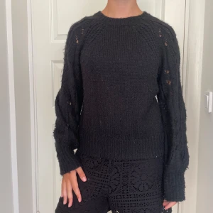 Svart stickad tröja från Kappahl - Mysig svart stickad tröja från Kappahl i storlek S. Tröjan har långärmade ärmar med snyggt hålmönster och ribbade muddar vid ärmslut och nederkant. Perfekt för lager-på-lager och chill höst- eller vinterstil. Skriv om du undrar något, kolla min profil innan du trycker på köp nu💕💕