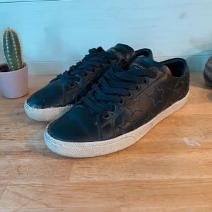 Svarta Saint Laurent sneakers med stjärnor - Svarta sneakers från Saint Laurent Paris i skinn. Pris: 1599 | Skick: 8/10 | Nypris ~ 2800 kr. Skicka gärna ett meddelande vid funderingar. Stl 39,5, men passar även 40-41. 