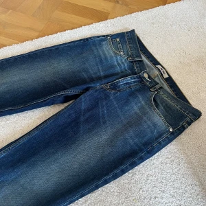 Blå raka jeans från Acne Studios - Säljer ett par klassiska blå jeans från Acne Studios med raka ben, normal passform och är tillverkade i robust denim. Perfekta för en avslappnad och stilren look. Storlek 33/34 på etiketten men skulle säga att de är små i storleken och sitter som 32/33, 32/34. Riktigt bra skick, nästan som nya. Pris går att diskuteras.