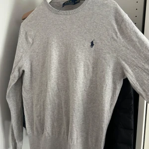 Grå stickad tröja från Polo Ralph Lauren - Snygg tröja från Ralph lauren. 7/10 skick förutom tagg som är halvt av i nacken 